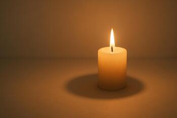 Candle casting a soft shadow arc