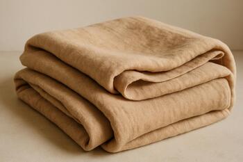 Folded linen throw in warm beige